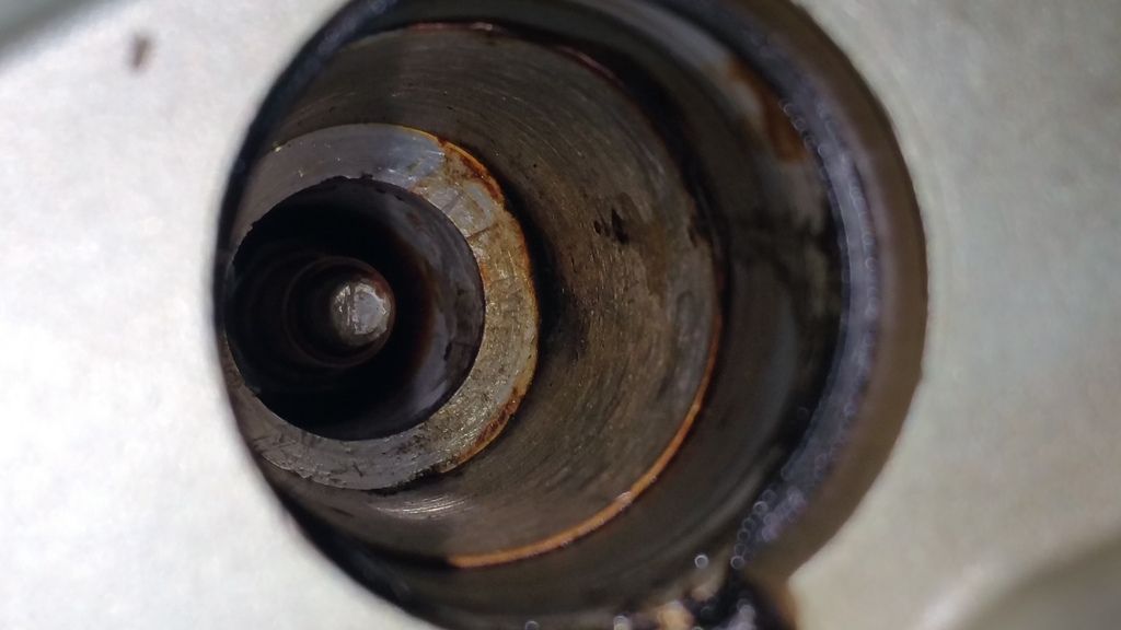 How should I clean the residue inside the coil pack/spark plug wells?